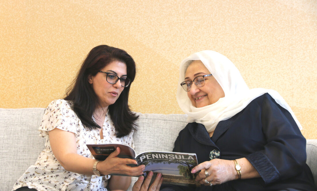 An Annecto Support Worker and an Annecto aged care customer reading a book.