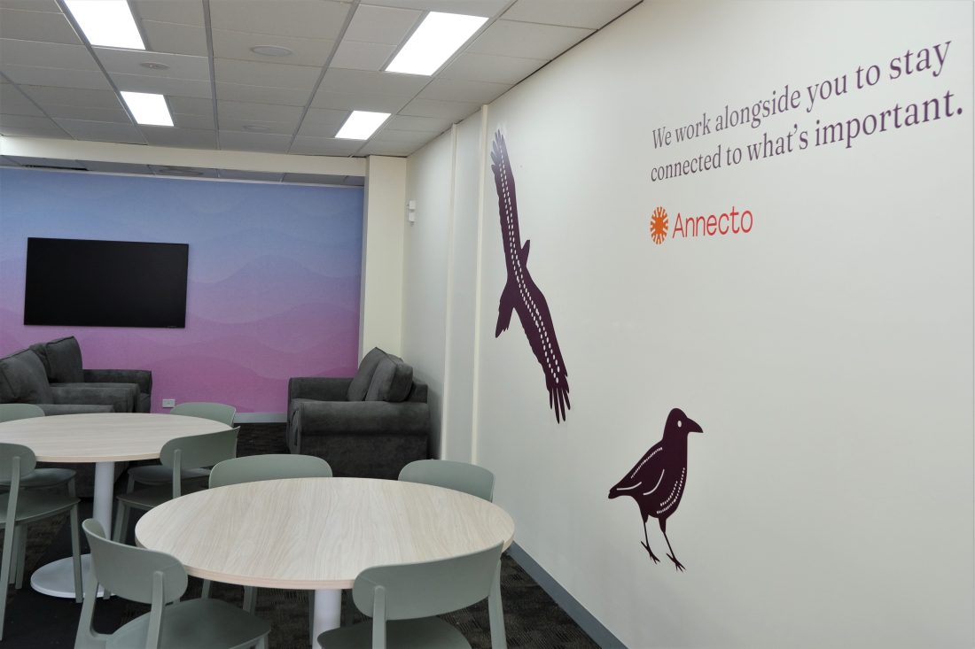 Picture of Annecto Ballarat office with a feature wave wall, the local Aboriginal totems and a catch phrase reading "We work alongside you to stay connected to what's important."