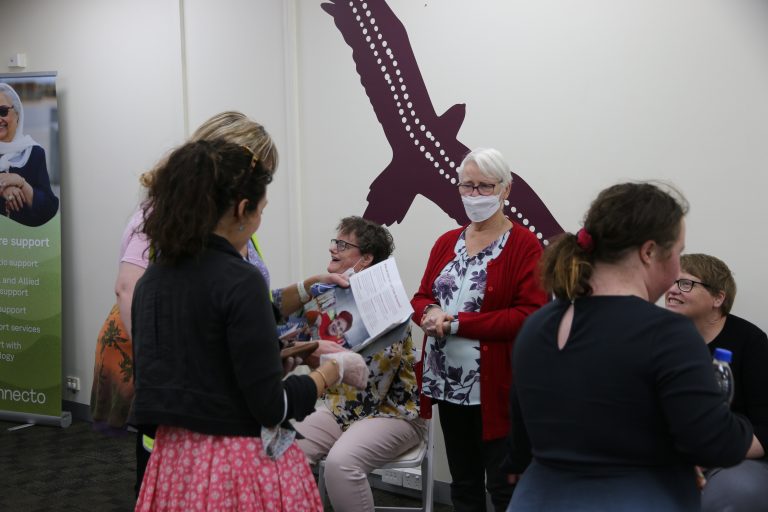 Annecto staff and customers looking at brochures and smiling in the Wendouree office