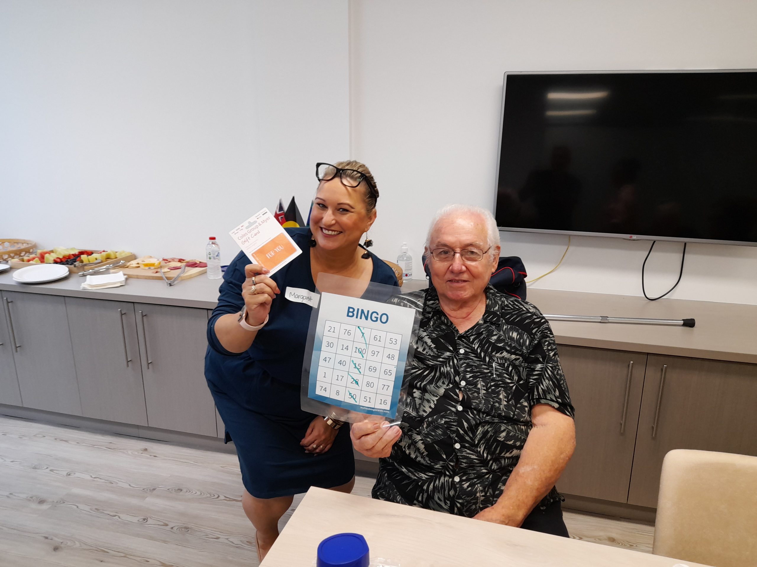Annecto staff member and a person we support playing bingo at our Sydney office in Mt Druitt.